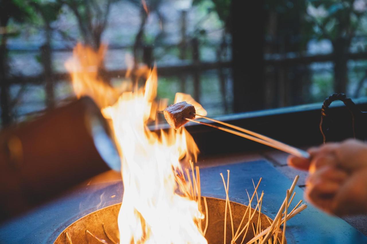 Отель Arima Onsen Tocen Goshobo Кобе Экстерьер фото A piece of meat being cooked over a fire